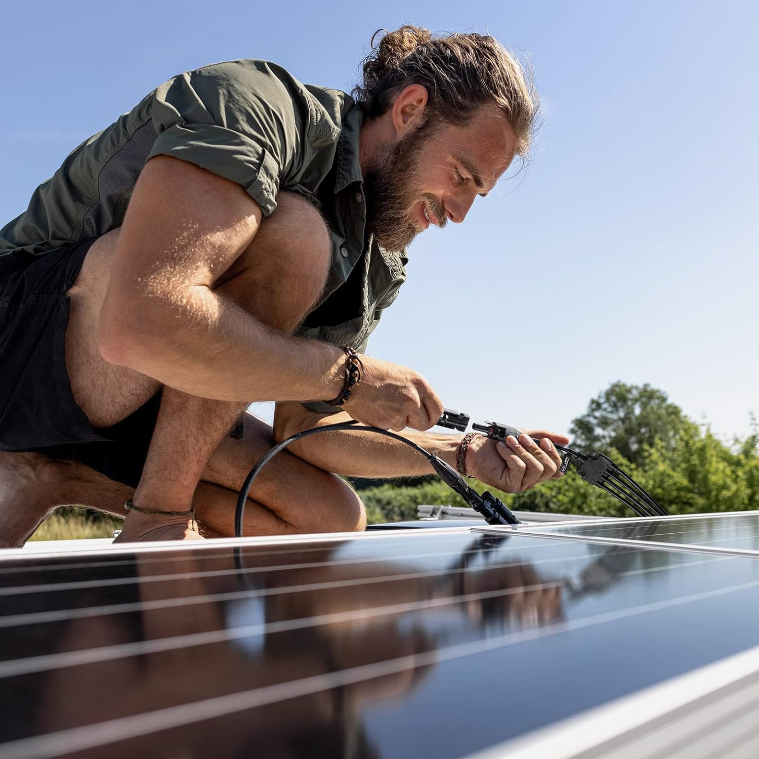Installer connecting BougeRV 4-to-1 branch cables on a solar array